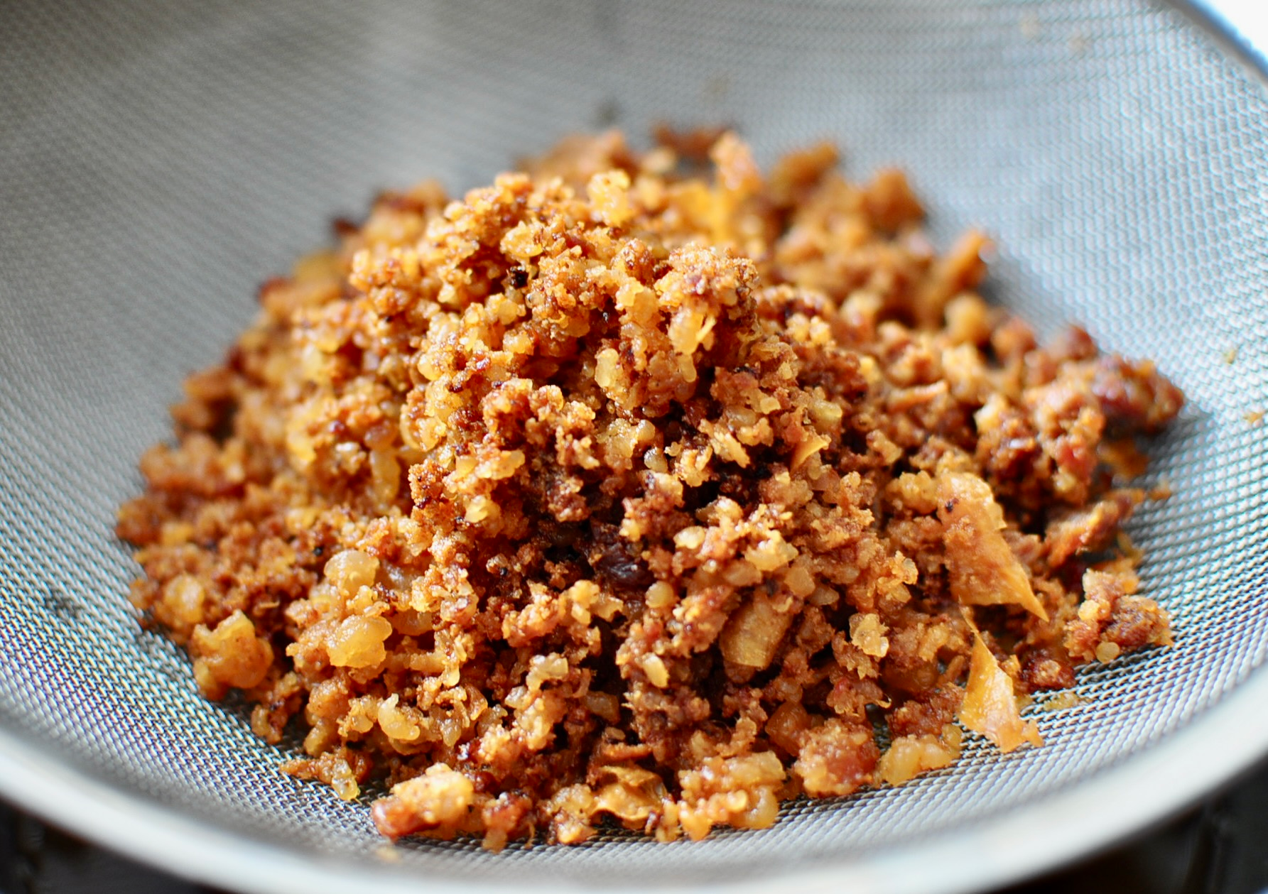 Cracklings straining on mesh strainer