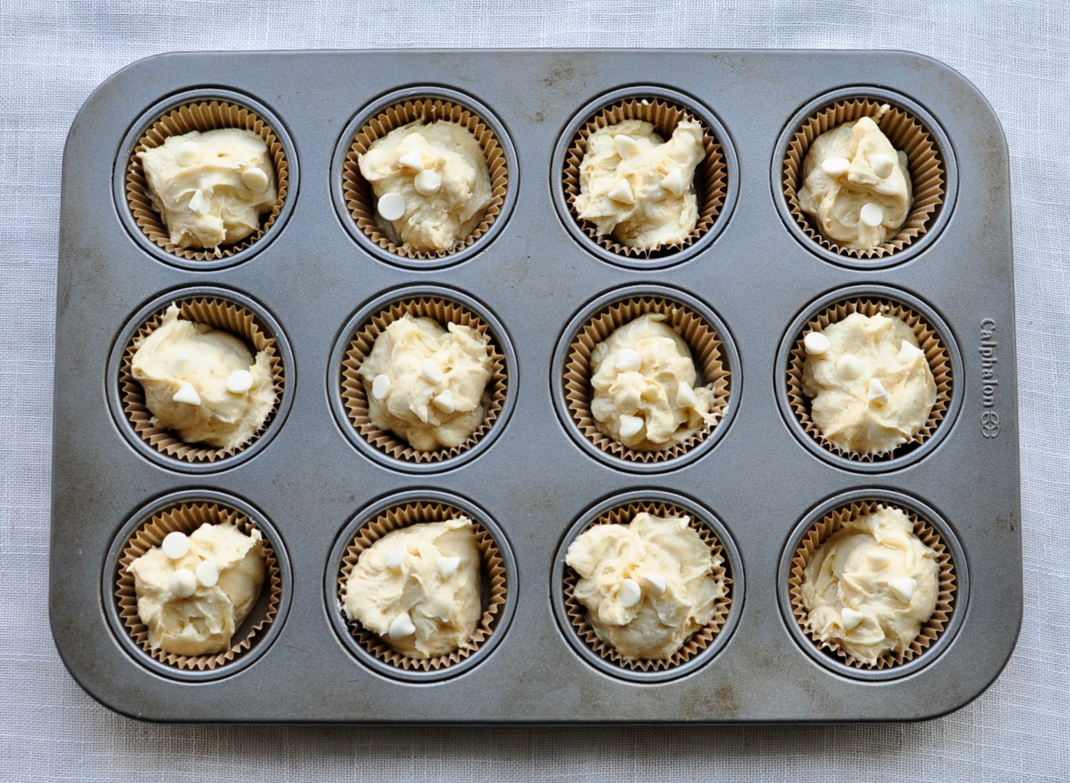 muffin tin with vanilla muffin batter