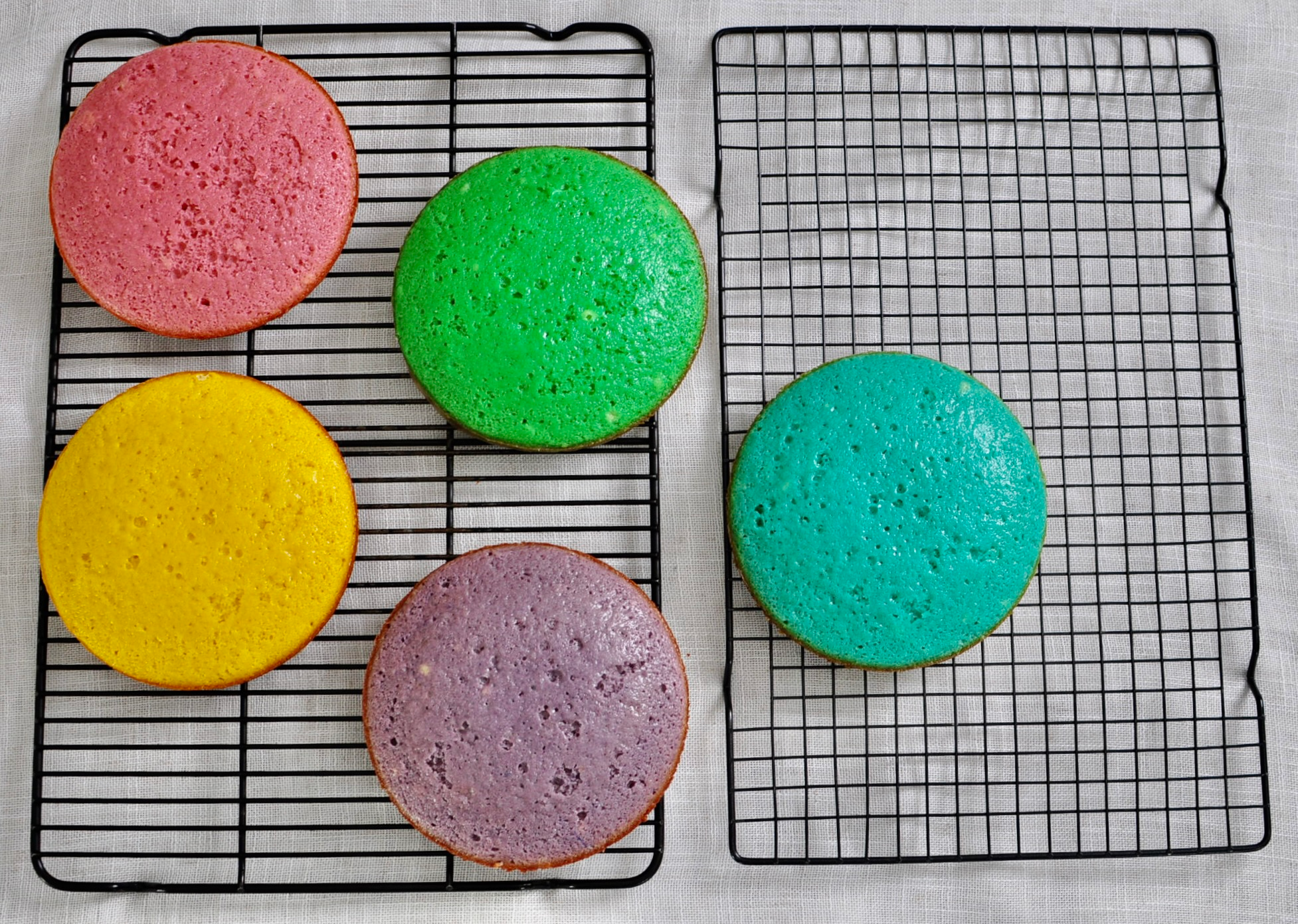 Rainbow vanilla cake cooling on wire rack