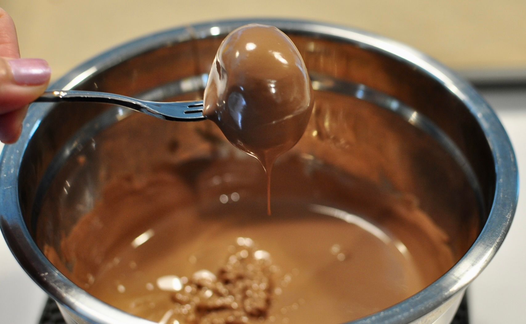 Dipping Oreo Truffles in Melted Chocolate